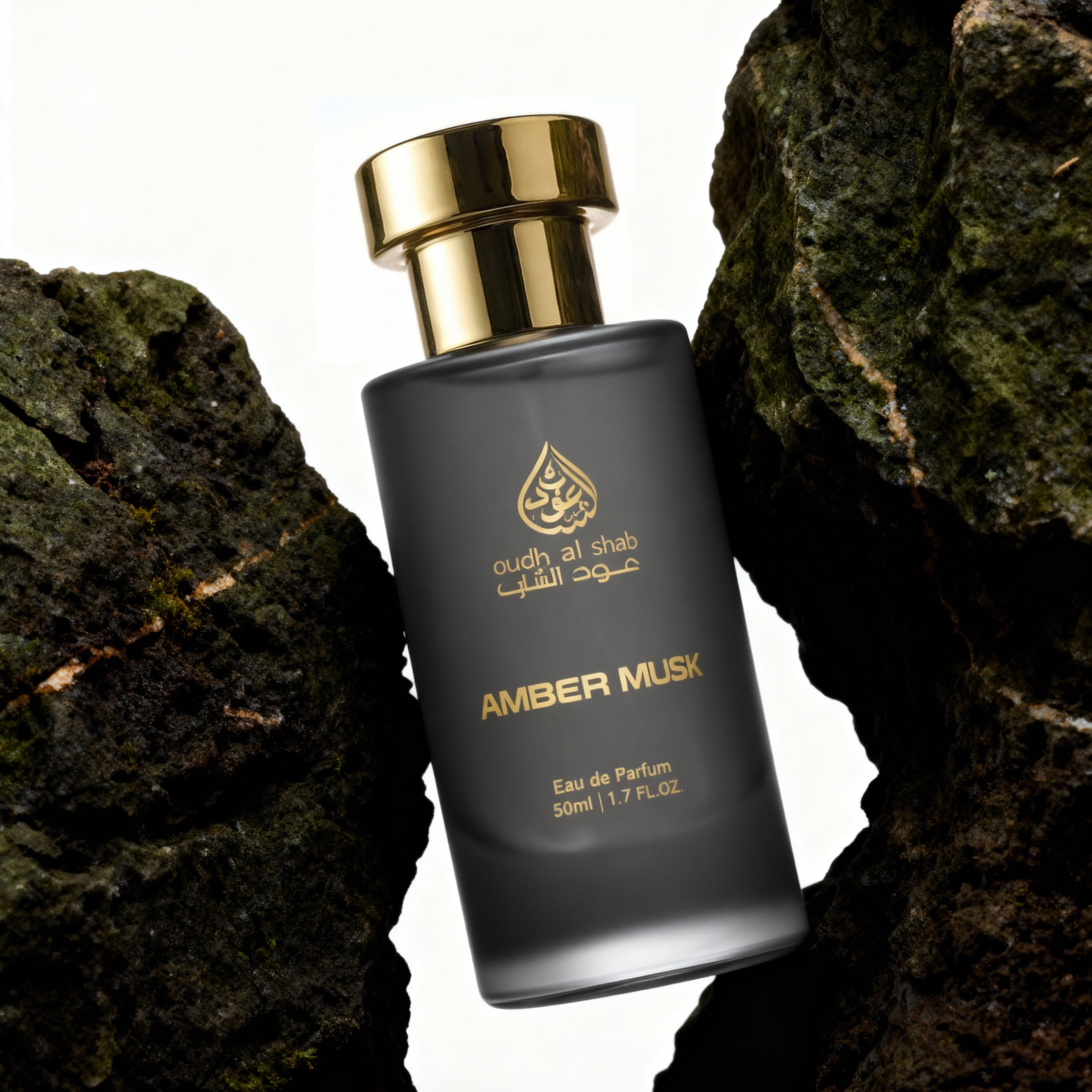 Perfume bottle labeled 'Amber Musk' by 'Oudh Al Sheik' against a rocky background
