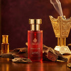 Red perfume bottle with gold cap on a wooden surface with decorative elements and smoke.